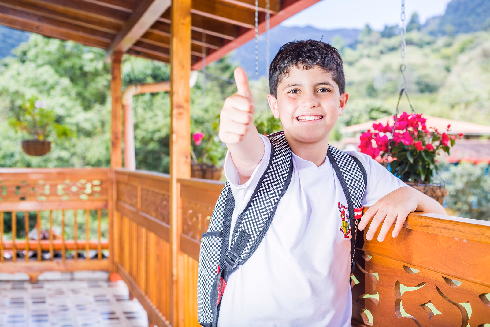 Un niño con uniforme escolar levanta el pulgar en una zona rural